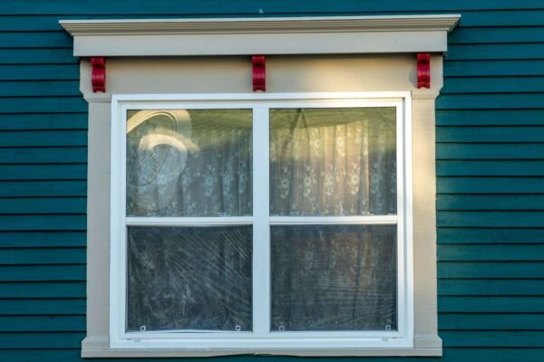 Ruka postavlja gumenu traku na okvir prozora za bolju izolaciju i sprječavanje propuha.