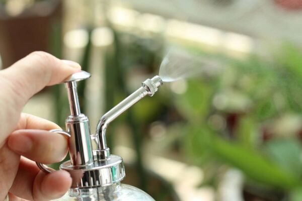 Ruke koje pomoću ključa zatežu slavinu kako bi zaustavile curenje vode, prikaz detalja popravka.