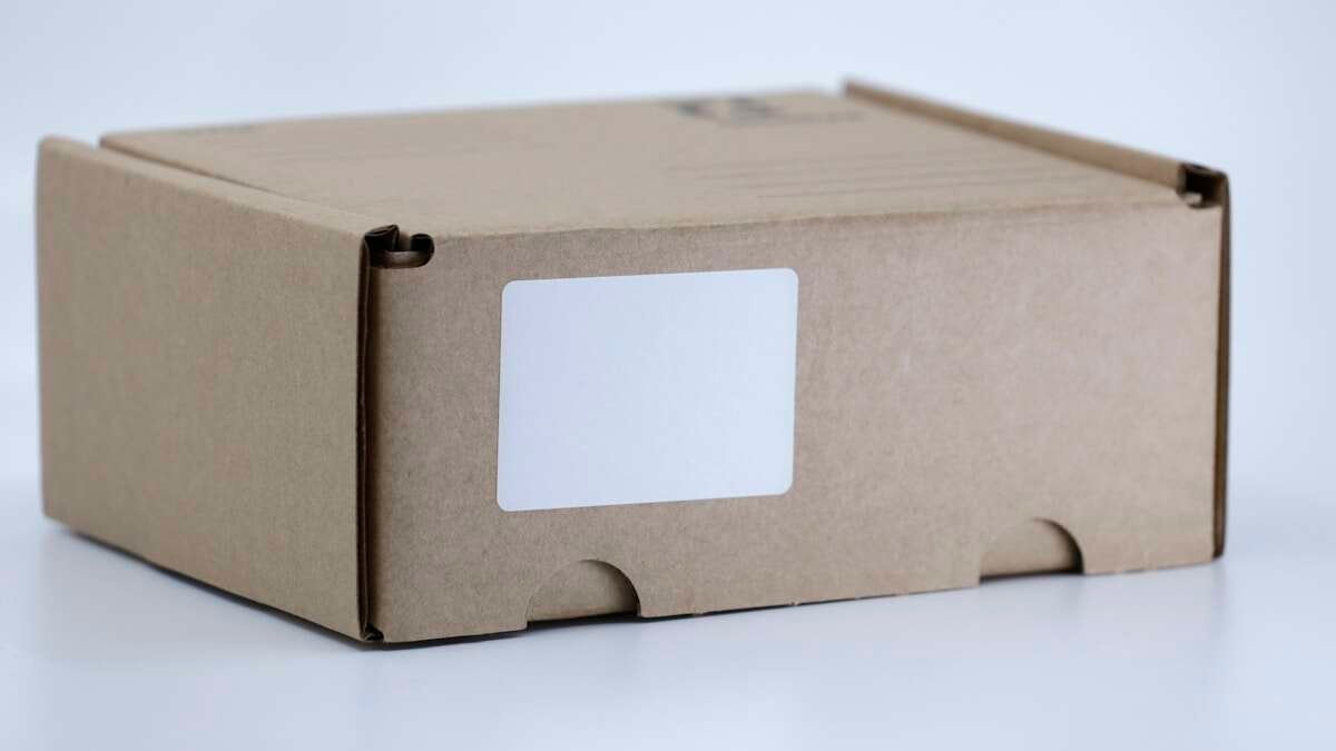 Osobe koje uklanjaju ljepljive trake s kartonskih kutija, pripremajući ih za recikliranje.