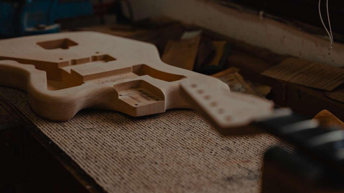 Alati za izradu gitara na radnom stolu, koji ilustriraju proces ručne izrade i zanatske tradicije.