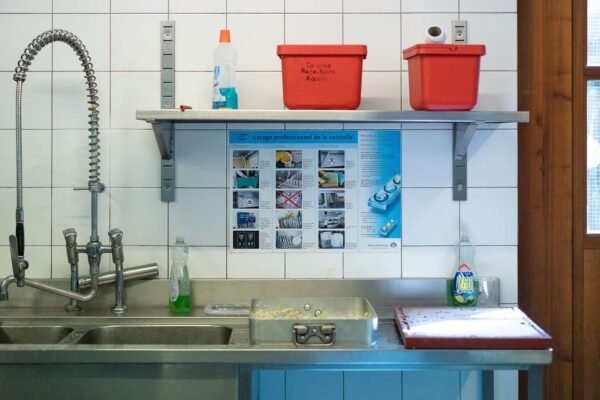 Bliski prikaz šarenih spremnika za razvrstavanje otpada u kuhinji, organiziranih za praktično korištenje.