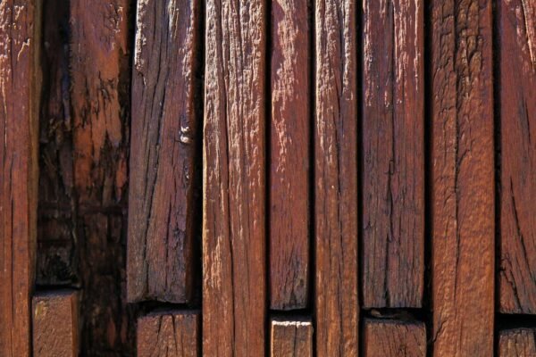 Blizak prikaz šarke na drvenim vratima, idealan za prikaz problema poput škripanja ili hrđe.