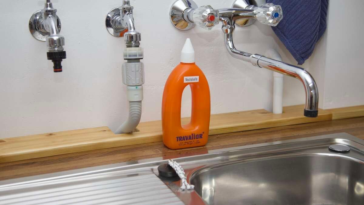 Prikaz sode bikarbone i octa pored sudopera, prikladnih za prirodno i ekološko čišćenje odvoda.