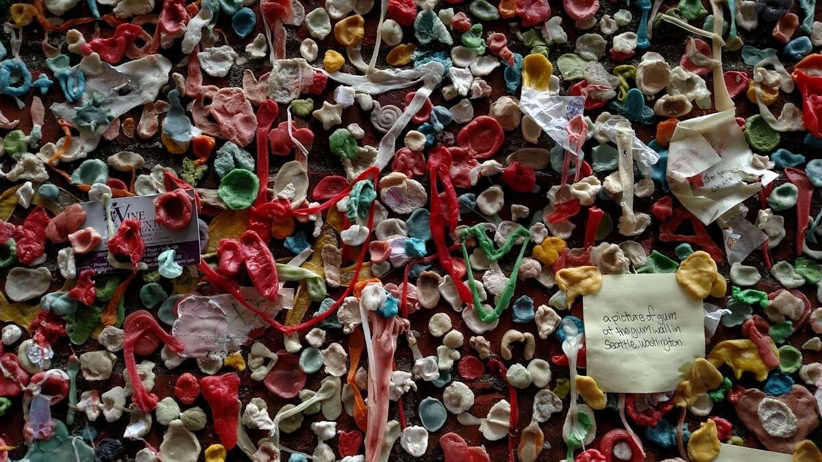 Prikaz ruku koje razvrstavaju plastični otpad s vidljivim simbolima za reciklažu na ambalaži.