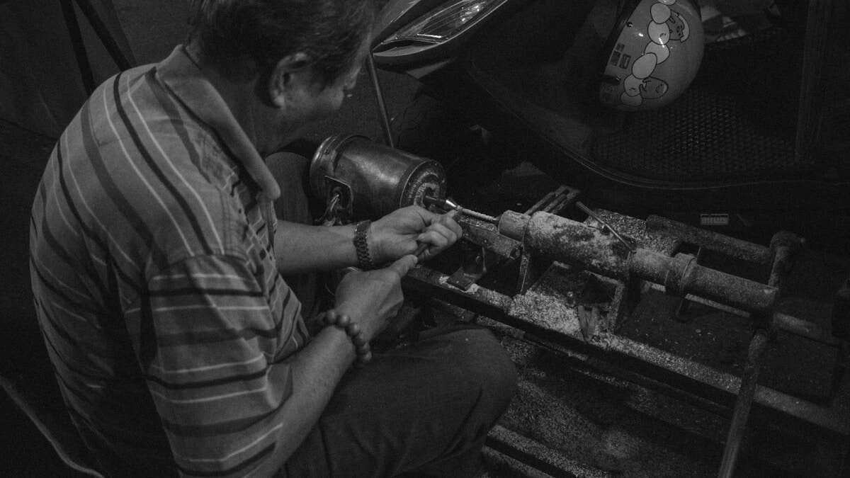 Majstor popravlja slavinu, s alatima i rukama u fokusu tijekom rada.