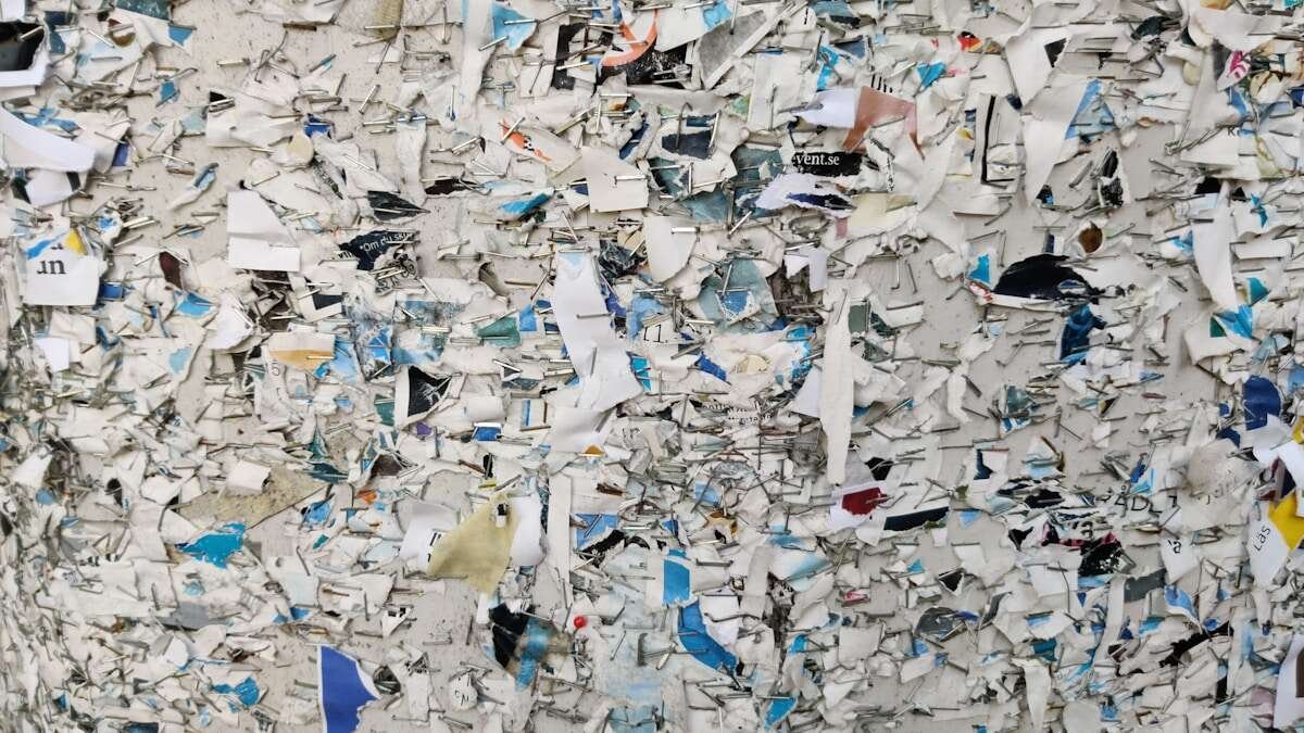 Konceptualna fotografija ruku koje odvajaju papir i plastiku u odgovarajuće spremnike za recikliranje.