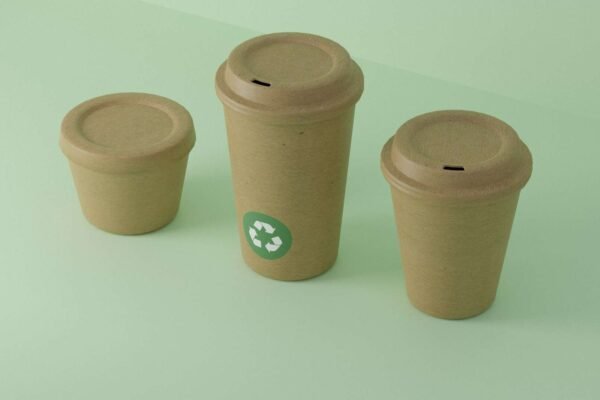 Plastični predmeti s vidljivim reciklažnim simbolima, prikazani na neutralnoj pozadini, korisni za edukaciju o recikliranju.