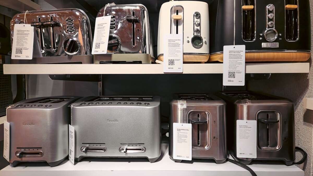 Mali kućanski uređaji poput tostera i kuhala za vodu u spremniku za reciklažu, naglašava važnost odvajanja e-otpada.