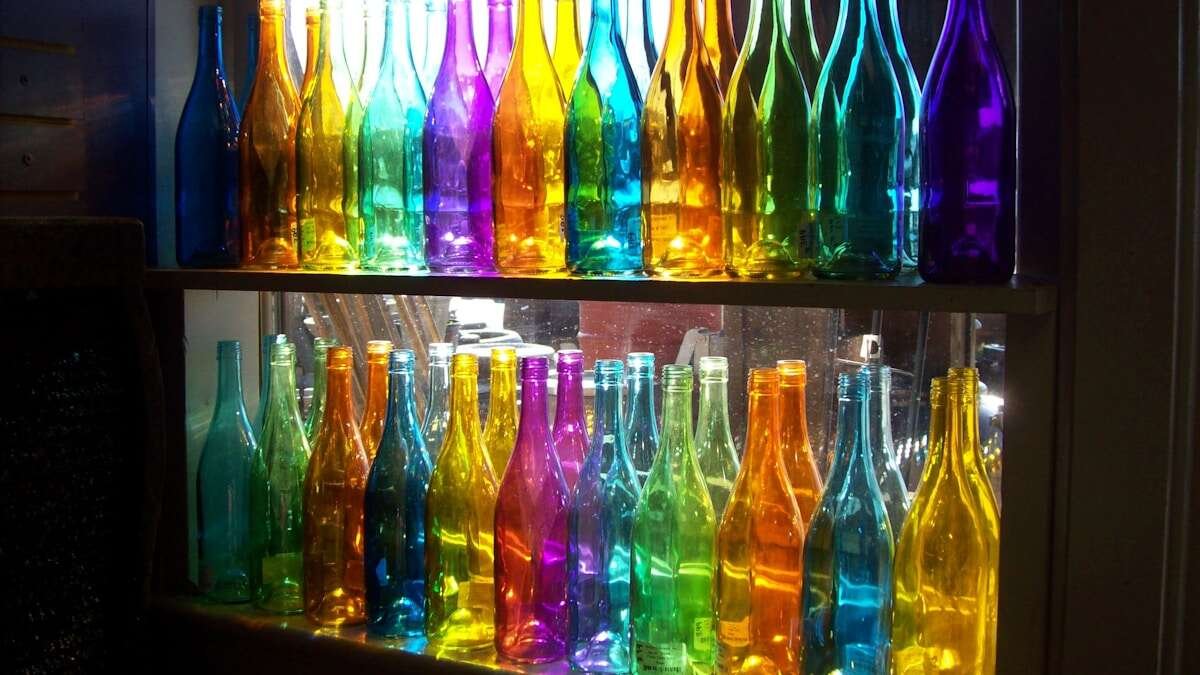 Pogled odozgo na staklene boce razvrstane prema boji, uključuje prozirno, zeleno i smeđe staklo.