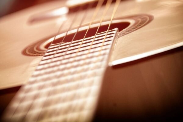 Blizak prikaz klasične gitare s drvenim tijelom i žicama, prikazuje detalje kvalitete izrade i tradicionalnog dizajna.