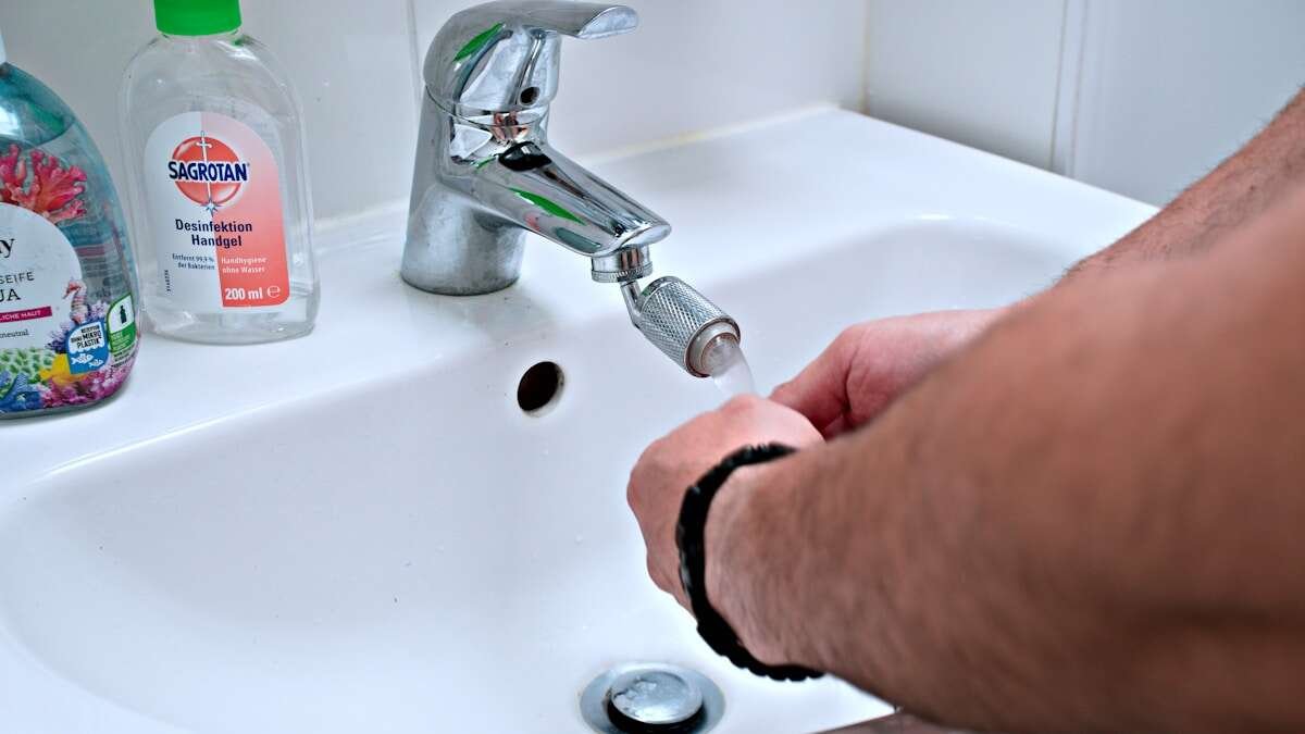 Ruke koriste gumeni odštopavač na umivaoniku u kupaonici, demonstrirajući jednostavno mehaničko čišćenje odvoda.