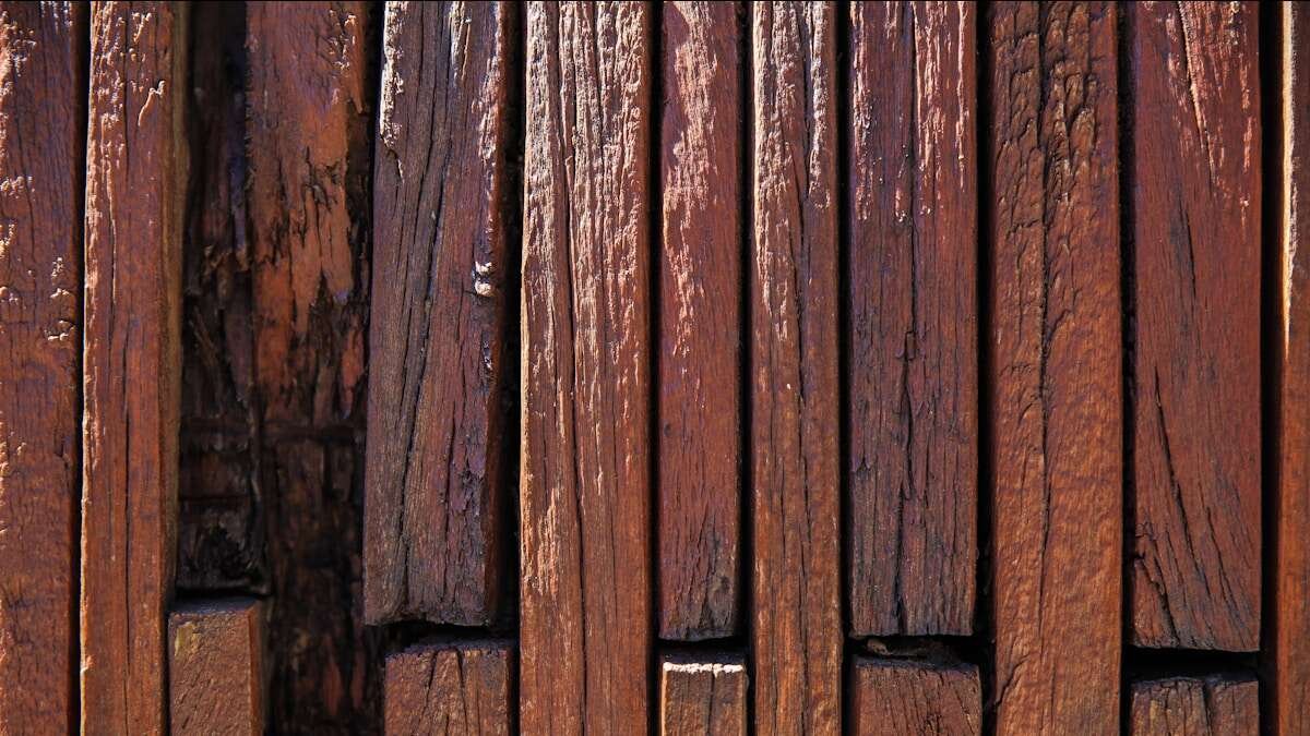 Osoba podešava drvena vrata odvijačem, prikaz procesa popravka izbliza.