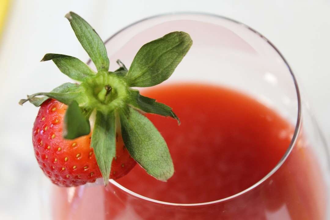 Čaša ispunjena živopisnim voćnim smoothiejem ukrašena svježim bobičastim voćem, odličan dodatak zdravoj prehrani.