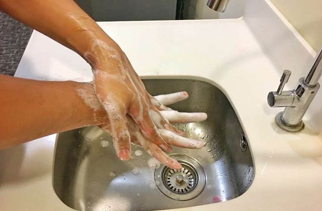 Približan prikaz ruku koje se peru sapunom pod mlazom vode, naglašavajući važnost higijene u prevenciji prehlade.