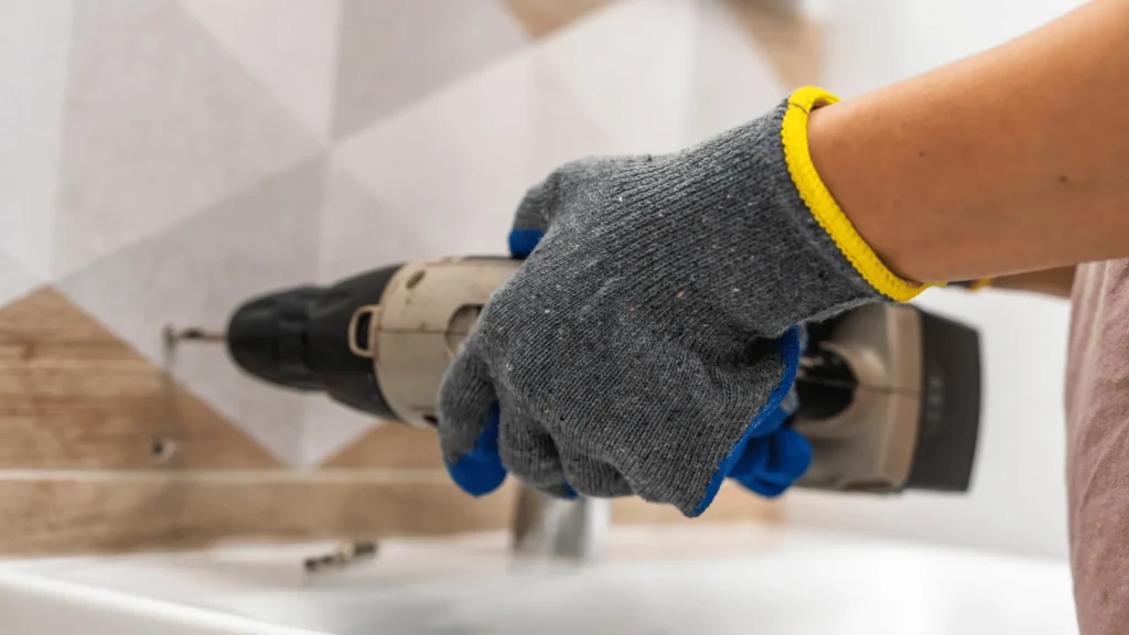 Uvod Bušenje rupa u pločicama i žbuci može biti pravi izazov, čak i za iskusne majstore. Pločice su krhke i sklone pucanju, a nepravilno bušenje može dovesti do ozbiljnih oštećenja koja zahtijevaju skup popravak. Isto tako, nepravilno bušenje može uzrokovati da rupa ne bude ravna, što može utjecati na estetiku i funkcionalnost prostora. Kako biste izbjegli ove probleme, važno je poznavati pravilne tehnike i koristiti odgovarajuće alate. U ovom članku istražit ćemo korake i trikove koji će vam pomoći da izbušite rupu upravo onako kako želite – ravno i bez oštećenja. Naučit ćete kako pravilno pripremiti površinu, odabrati pravi alat i primijeniti tehniku koja osigurava uspjeh. Bez obzira jeste li početnik ili imate iskustva, ove praktične savjete možete lako primijeniti u praksi. Uz detektore, specijalne bušilice i jednostavne zaštitne trikove, možete izbušiti rupu bez straha od pucanja pločica ili oštećenja žbuke. Krenimo s osnovama kako biste bili sigurni u svaki svoj korak. Što to znači Bušenje ravne i čiste rupe bez oštećenja znači da ste uspjeli probiti pločicu, zid ili žbuku bez stvaranja pukotina, neravnina ili mrlja. To je posebno važno u prostorijama poput kupaonica i kuhinja, gdje su pločice često dekorativni, ali i funkcionalni elementi. Oštećenje pločica ne samo da narušava estetiku prostora već može izazvati i probleme poput prodiranja vlage. Kada govorimo o “ravnoj rupi”, mislimo na rupu koja je izbušena okomito ili pod točno željenim kutom, bez odstupanja. Ovo je ključno za pravilno postavljanje vijaka, tipli ili nosača. Na primjer, ako postavljate nosač za ručnik u kupaonici, a rupa nije ravna, nosač može stajati ukoso, što nije samo neestetski već i nepraktično. Razumijevanje materijala s kojim radite također je ključ uspjeha. Pločice su često izrađene od keramike, porculana ili stakla, a svaki od ovih materijala ima svoje posebnosti. Keramika je mekša i lakša za bušenje, dok je porculan tvrđi i zahtijeva više pažnje. Žbuka, s druge strane, može biti mekana ili tvrda ovisno o vrsti i starosti zida. Kako funkcionira Priprema površine Priprema je ključna. Prvo, očistite površinu pločice ili zida kako biste uklonili prašinu i masnoće. Ovaj korak osigurava dobru vidljivost i sprječava klizanje bušilice. Ako bušite pločice, označite točno mjesto gdje želite napraviti rupu koristeći marker ili komad ljepljive trake. Ljepljiva traka također može pomoći u sprječavanju pucanja jer smanjuje vibracije. Odabir alata Pravi alati čine razliku. Za bušenje pločica preporučuje se uporaba bušilice s podesivom brzinom i svrdla za keramiku ili staklo. Ova svrdla obično imaju vrh obložen dijamantima ili volfram-karbidom, što ih čini dovoljno oštrim i izdržljivim. Ako bušite žbuku ili zid, koristite svrdla za beton i razmislite o korištenju udarne bušilice. Osoba priprema zid za bušenje pomoću zaštitne trake i ravnala, osiguravajući preciznost i zaštitu od oštećenja. Photo by Ömer Haktan Bulut on Unsplash Tijekom bušenja Prilikom bušenja, ključ je strpljenje. Započnite s niskom brzinom kako biste izbjegli pregrijavanje svrdla i oštećenje pločice. Kada probijete glazuru pločice, možete povećati brzinu, no uvijek pazite da ne forsirate bušilicu. Ako osjetite otpor, stanite i provjerite stanje svrdla i površine. Za dodatnu preciznost, koristite vodilicu za bušenje koja drži bušilicu stabilnom. Ovo je posebno korisno za početnike ili kod bušenja na klizavim površinama. Praktični primjeri Primjer 1: Postavljanje ogledala u kupaonici. Ako trebate izbušiti rupe za nosače ogledala, prvo označite točke na pločicama. Zalijepite komad trake preko oznake kako biste spriječili klizanje svrdla. Koristite svrdlo za keramiku i počnite bušiti na niskoj brzini. Nakon što probijete pločicu, zamijenite svrdlo onim za beton kako biste nastavili bušenje u zidu. Primjer 2: Montaža kuhinjskih polica. Kod bušenja kroz keramičke pločice u kuhinji, postupak je sličan – koristite marker za precizno označavanje, ljepljivu traku za zaštitu i svrdla za keramiku i beton. Također, uvijek provjerite ima li ispod pločice električnih instalacija pomoću detektora. Primjer 3: Bušenje rupa na vanjskim zidovima. Ako bušite kroz žbuku ili opeku, koristite udarnu bušilicu i svrdla za beton. Pripremite područje oko mjesta bušenja kako biste uhvatili prašinu, primjerice pomoću ljepljive trake postavljene ispod rupe. Benefiti i primjena Pravilno bušenje ne samo da osigurava estetski rezultat već i produljuje vijek trajanja pločica i zida. Osim toga, pravilno izbušene rupe omogućuju sigurno postavljanje nosača, polica, ogledala i drugih elemenata. Ovo je posebno važno u prostorima koji su izloženi vlazi ili čestim promjenama temperature, poput kupaonica i vanjskih zidova. Primjena ovih tehnika nije ograničena samo na kućanstva. Mnoge industrije, uključujući građevinu i dizajn interijera, oslanjaju se na precizno bušenje kako bi osigurale kvalitetu i sigurnost svojih projekata. Na primjer, postavljanje staklenih pregrada u uredima zahtijeva precizno bušenje rupa kroz staklo i pločice. Osim toga, pravilno bušenje smanjuje rizik od skupih popravaka. Puknuta pločica često zahtijeva zamjenu cijele plohe, što može biti skupo i dugotrajno. Primjenom pravilnih tehnika izbjegavate te probleme. Blizak prikaz svrdla za bušenje porculanskih pločica, ilustrirajući specijalizirani alat za izbjegavanje pucanja pločica. Photo by Declan Sun on Unsplash Najčešća pitanja Kako spriječiti klizanje bušilice na pločici? Zalijepite komad ljepljive trake preko mjesta gdje želite bušiti. Traka stvara trenje i sprječava klizanje svrdla. Također, koristite bušilicu s niskom brzinom na početku. Koje svrdlo koristiti za pločice? Koristite svrdla s vrhom od volfram-karbida ili dijamanta. Ova svrdla su posebno dizajnirana za rad s tvrdim i krhkim materijalima poput pločica. Što učiniti ako pločica pukne? Ako pločica pukne, odmah prekinite bušenje. Uklonite oštećenu pločicu i zamijenite je novom. Prije ponovnog bušenja, provjerite je li svrdlo ispravno i koristite zaštitne mjere poput ljepljive trake. Zaključak Bušenje rupa u pločicama i žbuci može zvučati zastrašujuće, ali uz pravu tehniku, alate i pripremu, možete izbjeći pucanje i oštećenja. Ključ uspjeha je u strpljenju, preciznosti i korištenju odgovarajuće opreme. Bez obzira radite li na renovaciji kupaonice, postavljanju kuhinjskih polica ili instaliranju dekoracija, ovim savjetima osigurat ćete profesionalne rezultate. Sljedeći put kada se suočite s izazovom bušenja, prisjetite se ovog vodiča i budite sigurni da ćete posao obaviti bez stresa i neugodnih iznenađenja. Više ovakvih tema pročitajte u kategoriji: DIY i uređenje doma