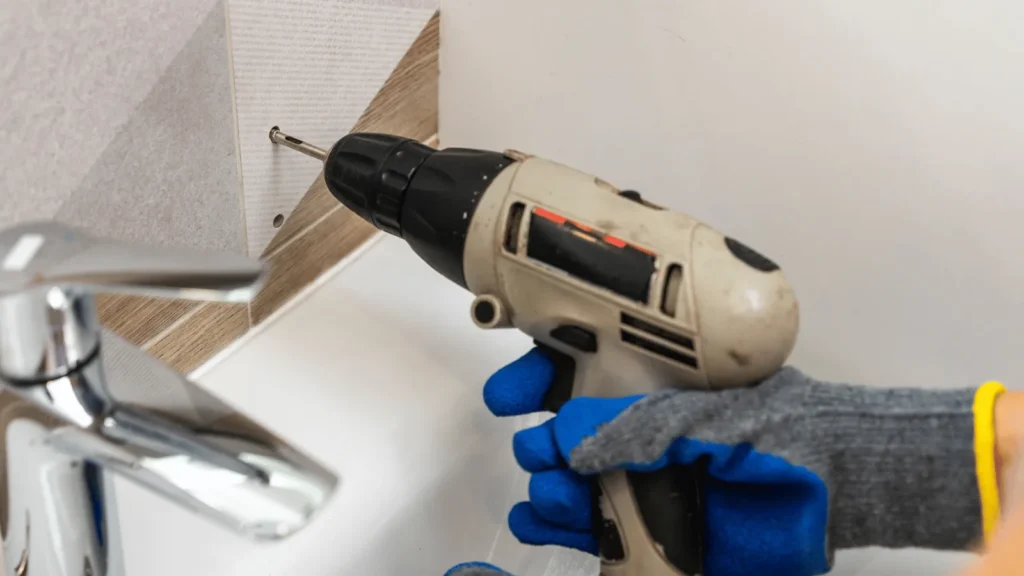 Uvod Bušenje rupa u pločicama i žbuci može biti pravi izazov, čak i za iskusne majstore. Pločice su krhke i sklone pucanju, a nepravilno bušenje može dovesti do ozbiljnih oštećenja koja zahtijevaju skup popravak. Isto tako, nepravilno bušenje može uzrokovati da rupa ne bude ravna, što može utjecati na estetiku i funkcionalnost prostora. Kako biste izbjegli ove probleme, važno je poznavati pravilne tehnike i koristiti odgovarajuće alate. U ovom članku istražit ćemo korake i trikove koji će vam pomoći da izbušite rupu upravo onako kako želite – ravno i bez oštećenja. Naučit ćete kako pravilno pripremiti površinu, odabrati pravi alat i primijeniti tehniku koja osigurava uspjeh. Bez obzira jeste li početnik ili imate iskustva, ove praktične savjete možete lako primijeniti u praksi. Uz detektore, specijalne bušilice i jednostavne zaštitne trikove, možete izbušiti rupu bez straha od pucanja pločica ili oštećenja žbuke. Krenimo s osnovama kako biste bili sigurni u svaki svoj korak. Što to znači Bušenje ravne i čiste rupe bez oštećenja znači da ste uspjeli probiti pločicu, zid ili žbuku bez stvaranja pukotina, neravnina ili mrlja. To je posebno važno u prostorijama poput kupaonica i kuhinja, gdje su pločice često dekorativni, ali i funkcionalni elementi. Oštećenje pločica ne samo da narušava estetiku prostora već može izazvati i probleme poput prodiranja vlage. Kada govorimo o “ravnoj rupi”, mislimo na rupu koja je izbušena okomito ili pod točno željenim kutom, bez odstupanja. Ovo je ključno za pravilno postavljanje vijaka, tipli ili nosača. Na primjer, ako postavljate nosač za ručnik u kupaonici, a rupa nije ravna, nosač može stajati ukoso, što nije samo neestetski već i nepraktično. Razumijevanje materijala s kojim radite također je ključ uspjeha. Pločice su često izrađene od keramike, porculana ili stakla, a svaki od ovih materijala ima svoje posebnosti. Keramika je mekša i lakša za bušenje, dok je porculan tvrđi i zahtijeva više pažnje. Žbuka, s druge strane, može biti mekana ili tvrda ovisno o vrsti i starosti zida. Kako funkcionira Priprema površine Priprema je ključna. Prvo, očistite površinu pločice ili zida kako biste uklonili prašinu i masnoće. Ovaj korak osigurava dobru vidljivost i sprječava klizanje bušilice. Ako bušite pločice, označite točno mjesto gdje želite napraviti rupu koristeći marker ili komad ljepljive trake. Ljepljiva traka također može pomoći u sprječavanju pucanja jer smanjuje vibracije. Odabir alata Pravi alati čine razliku. Za bušenje pločica preporučuje se uporaba bušilice s podesivom brzinom i svrdla za keramiku ili staklo. Ova svrdla obično imaju vrh obložen dijamantima ili volfram-karbidom, što ih čini dovoljno oštrim i izdržljivim. Ako bušite žbuku ili zid, koristite svrdla za beton i razmislite o korištenju udarne bušilice. Osoba priprema zid za bušenje pomoću zaštitne trake i ravnala, osiguravajući preciznost i zaštitu od oštećenja. Photo by Ömer Haktan Bulut on Unsplash Tijekom bušenja Prilikom bušenja, ključ je strpljenje. Započnite s niskom brzinom kako biste izbjegli pregrijavanje svrdla i oštećenje pločice. Kada probijete glazuru pločice, možete povećati brzinu, no uvijek pazite da ne forsirate bušilicu. Ako osjetite otpor, stanite i provjerite stanje svrdla i površine. Za dodatnu preciznost, koristite vodilicu za bušenje koja drži bušilicu stabilnom. Ovo je posebno korisno za početnike ili kod bušenja na klizavim površinama. Praktični primjeri Primjer 1: Postavljanje ogledala u kupaonici. Ako trebate izbušiti rupe za nosače ogledala, prvo označite točke na pločicama. Zalijepite komad trake preko oznake kako biste spriječili klizanje svrdla. Koristite svrdlo za keramiku i počnite bušiti na niskoj brzini. Nakon što probijete pločicu, zamijenite svrdlo onim za beton kako biste nastavili bušenje u zidu. Primjer 2: Montaža kuhinjskih polica. Kod bušenja kroz keramičke pločice u kuhinji, postupak je sličan – koristite marker za precizno označavanje, ljepljivu traku za zaštitu i svrdla za keramiku i beton. Također, uvijek provjerite ima li ispod pločice električnih instalacija pomoću detektora. Primjer 3: Bušenje rupa na vanjskim zidovima. Ako bušite kroz žbuku ili opeku, koristite udarnu bušilicu i svrdla za beton. Pripremite područje oko mjesta bušenja kako biste uhvatili prašinu, primjerice pomoću ljepljive trake postavljene ispod rupe. Benefiti i primjena Pravilno bušenje ne samo da osigurava estetski rezultat već i produljuje vijek trajanja pločica i zida. Osim toga, pravilno izbušene rupe omogućuju sigurno postavljanje nosača, polica, ogledala i drugih elemenata. Ovo je posebno važno u prostorima koji su izloženi vlazi ili čestim promjenama temperature, poput kupaonica i vanjskih zidova. Primjena ovih tehnika nije ograničena samo na kućanstva. Mnoge industrije, uključujući građevinu i dizajn interijera, oslanjaju se na precizno bušenje kako bi osigurale kvalitetu i sigurnost svojih projekata. Na primjer, postavljanje staklenih pregrada u uredima zahtijeva precizno bušenje rupa kroz staklo i pločice. Osim toga, pravilno bušenje smanjuje rizik od skupih popravaka. Puknuta pločica često zahtijeva zamjenu cijele plohe, što može biti skupo i dugotrajno. Primjenom pravilnih tehnika izbjegavate te probleme. Blizak prikaz svrdla za bušenje porculanskih pločica, ilustrirajući specijalizirani alat za izbjegavanje pucanja pločica. Photo by Declan Sun on Unsplash Najčešća pitanja Kako spriječiti klizanje bušilice na pločici? Zalijepite komad ljepljive trake preko mjesta gdje želite bušiti. Traka stvara trenje i sprječava klizanje svrdla. Također, koristite bušilicu s niskom brzinom na početku. Koje svrdlo koristiti za pločice? Koristite svrdla s vrhom od volfram-karbida ili dijamanta. Ova svrdla su posebno dizajnirana za rad s tvrdim i krhkim materijalima poput pločica. Što učiniti ako pločica pukne? Ako pločica pukne, odmah prekinite bušenje. Uklonite oštećenu pločicu i zamijenite je novom. Prije ponovnog bušenja, provjerite je li svrdlo ispravno i koristite zaštitne mjere poput ljepljive trake. Zaključak Bušenje rupa u pločicama i žbuci može zvučati zastrašujuće, ali uz pravu tehniku, alate i pripremu, možete izbjeći pucanje i oštećenja. Ključ uspjeha je u strpljenju, preciznosti i korištenju odgovarajuće opreme. Bez obzira radite li na renovaciji kupaonice, postavljanju kuhinjskih polica ili instaliranju dekoracija, ovim savjetima osigurat ćete profesionalne rezultate. Sljedeći put kada se suočite s izazovom bušenja, prisjetite se ovog vodiča i budite sigurni da ćete posao obaviti bez stresa i neugodnih iznenađenja. Više ovakvih tema pročitajte u kategoriji: DIY i uređenje doma