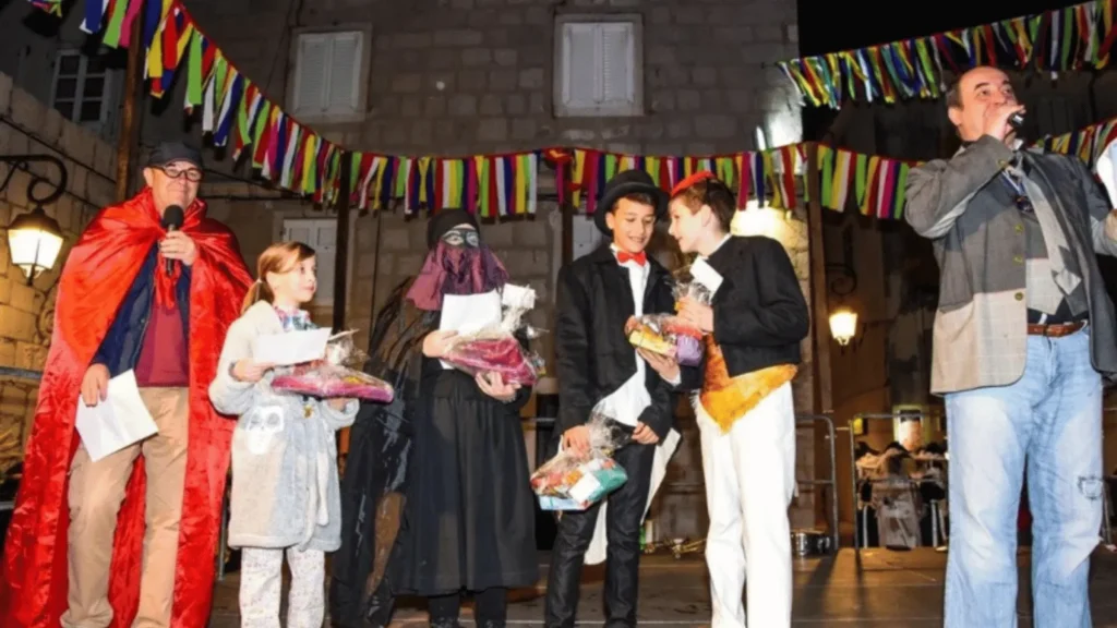 Sudionici Paškog zimskog karnevala u tradicionalnim maskama na gradskom trgu u Pagu