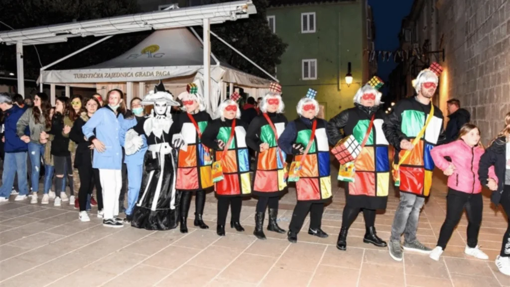 Sudionici Paškog zimskog karnevala u tradicionalnim maskama na gradskom trgu u Pagu