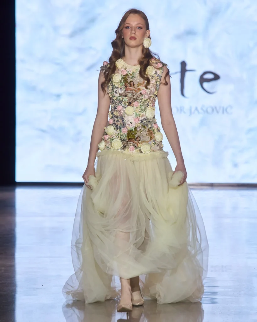 Krem haljina s floralno ukrašenim gornjim dijelom i voluminoznom tulle suknjom iz ARTE kolekcije.