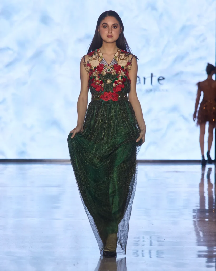 Zelena večernja haljina s crvenim cvjetnim aplikacijama i bogatom teksturom.