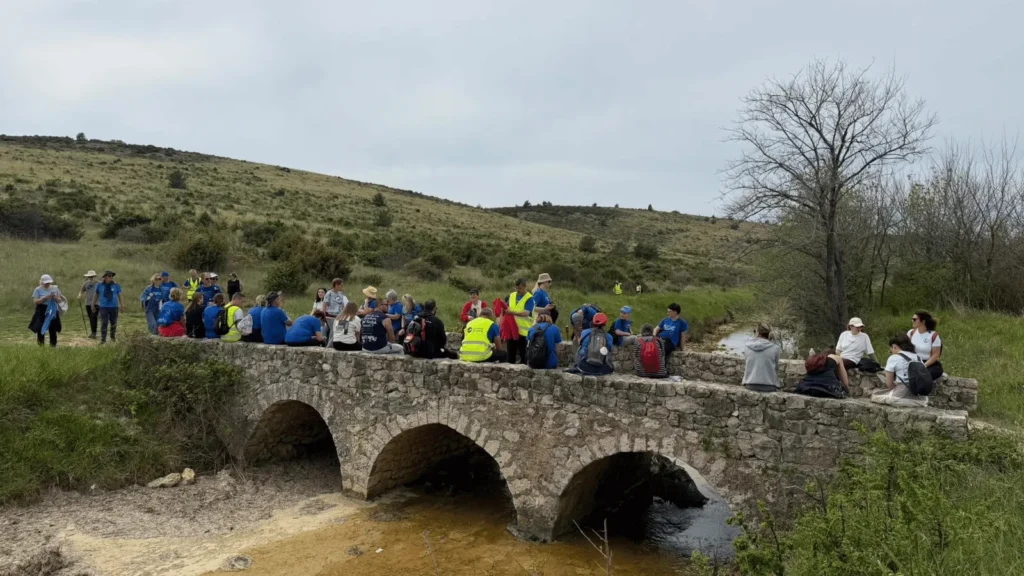 Hodočasnici Camino Zadar rute okupljeni na starom kamenom mostu okruženi prirodom Zadarske županije