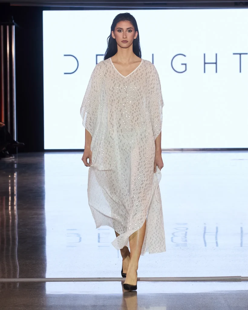 Bijela lepršava maxi haljina od laganog prozirnog materijala prikazana na Delight pisti.