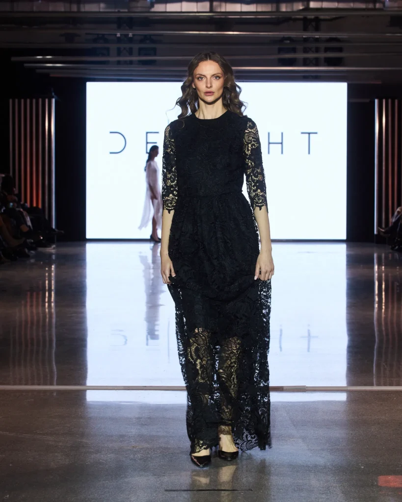 Crna maxi haljina od čipke s dugim rukavima i romantičnom siluetom.