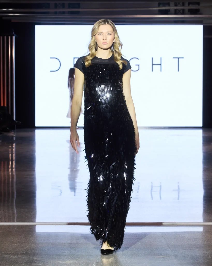 Crna maxi haljina s dugim sjajnim aplikacijama koje stvaraju dramatičan vizualni efekt.