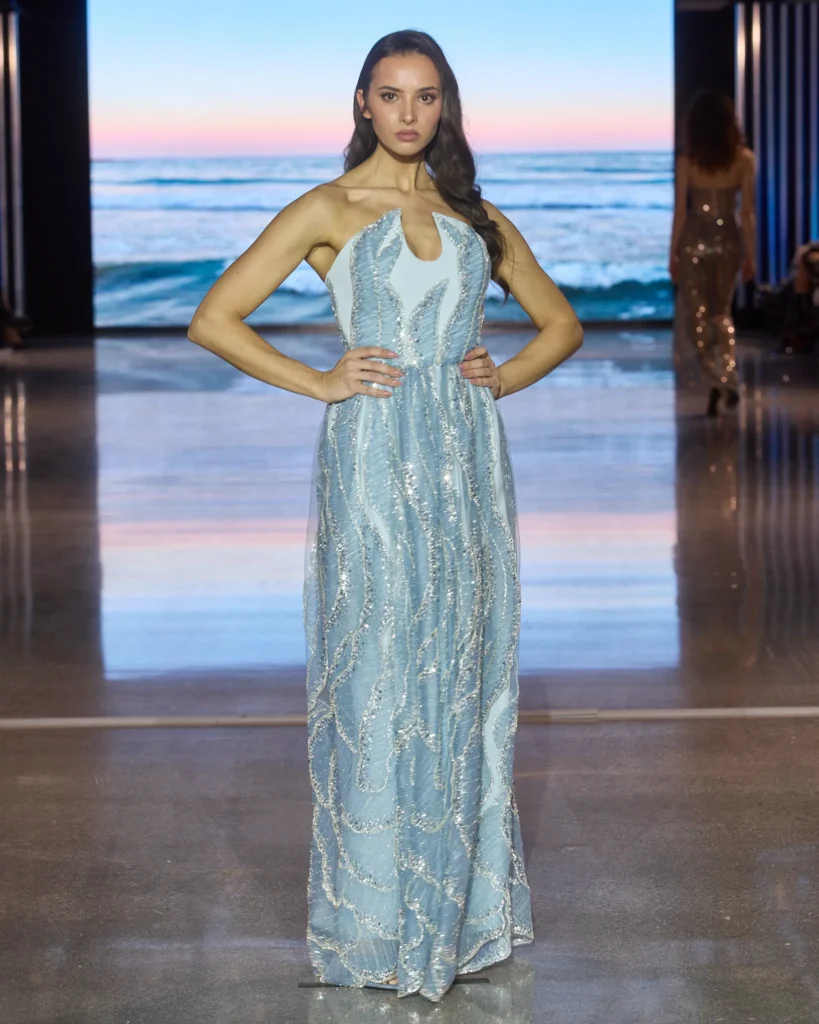 Plava večernja haljina s halter izrezom i srebrnim ukrasnim vezom.