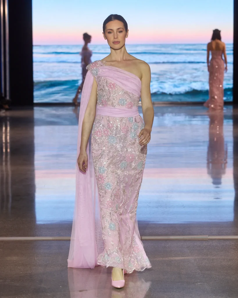 Roza večernja haljina na jedno rame izrađena od čipke s pastelno sjajnim vezom.