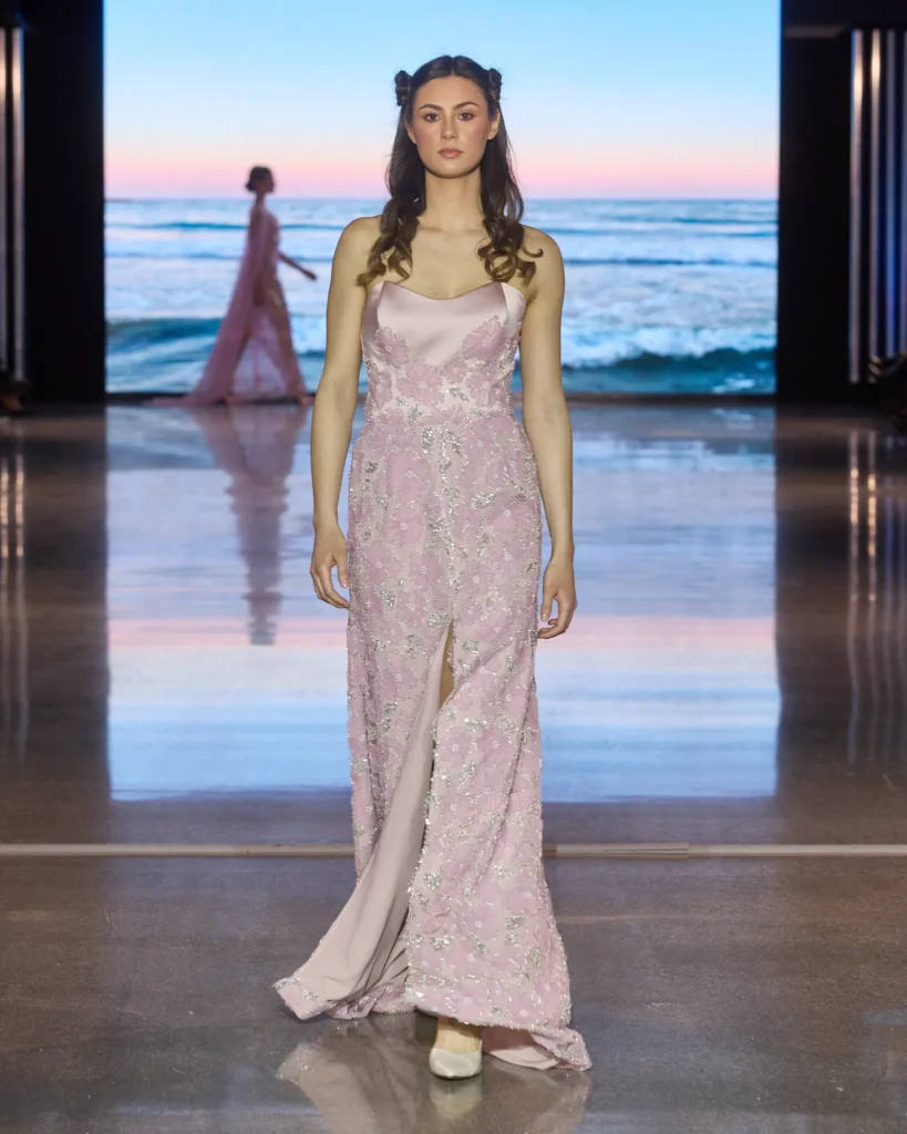 Duga roza haljina od satena i čipke s visokim prorezom i cvjetnim aplikacijama.