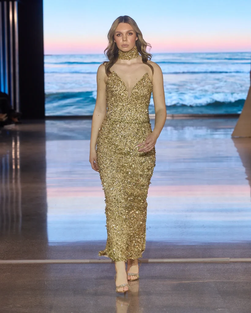 Elegantna midi haljina u zlatnoj boji s gustim šljokicama i uskom siluetom.