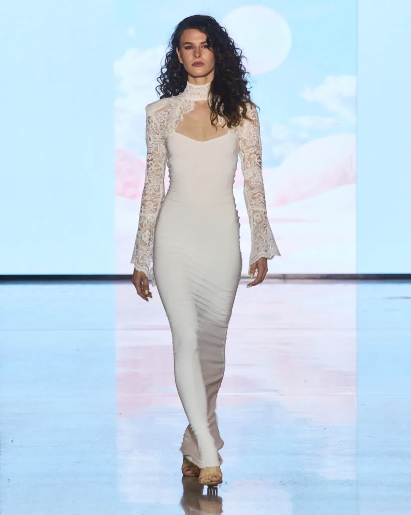 Bijela maksi haljina s čipkanim gornjim dijelom, visokim ovratnikom i pripijenom siluetom.