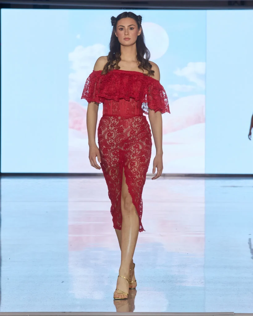 Crvena midi haljina od čipke, spuštenih ramena i gornjeg volan detalja.