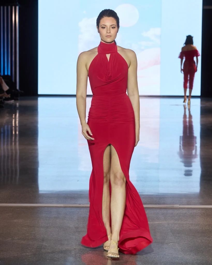 Crvena večernja haljina s halter izrezom, pripijenom siluetom i visokim prorezom.