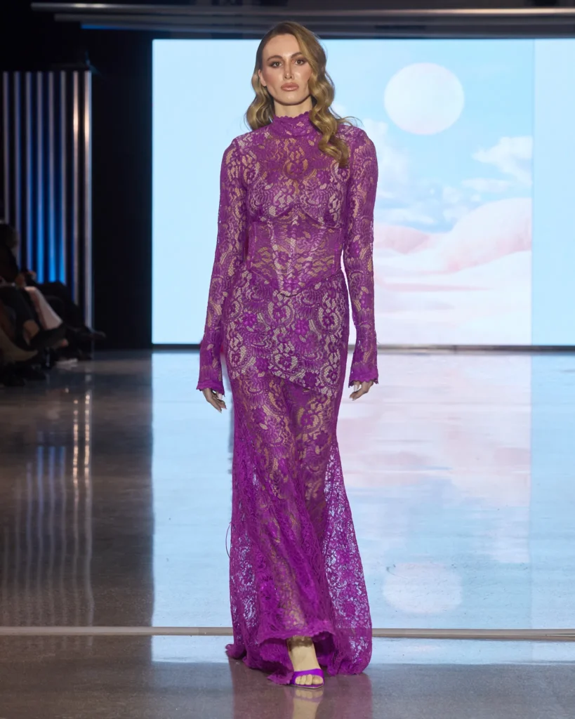 Magentna maksi haljina izrađena od čipke s visokim ovratnikom i dugim rukavima.