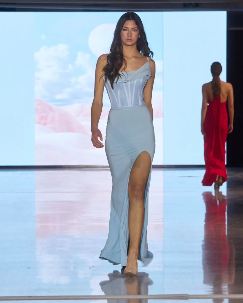 Svijetlo plava haljina s korsetnim gornjim dijelom, drapiranim ramenima i prednjim prorezom.