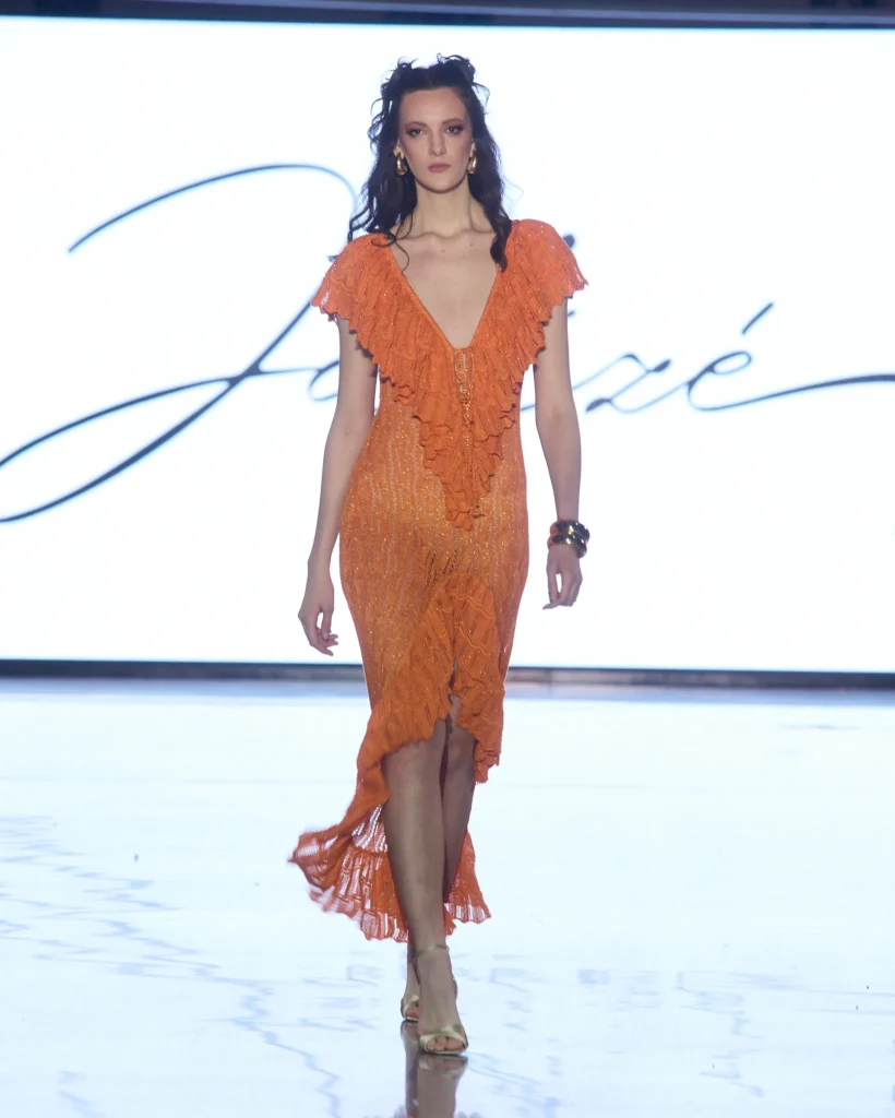 Narančasta pletena haljina s V izrezom i bogatim volan detaljima.