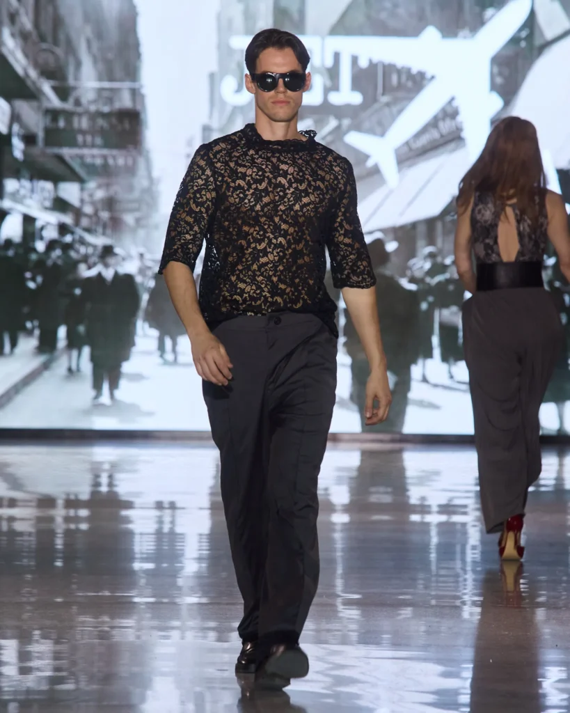 Muška crna čipkana majica u kombinaciji s tamnim elegantnim hlačama.