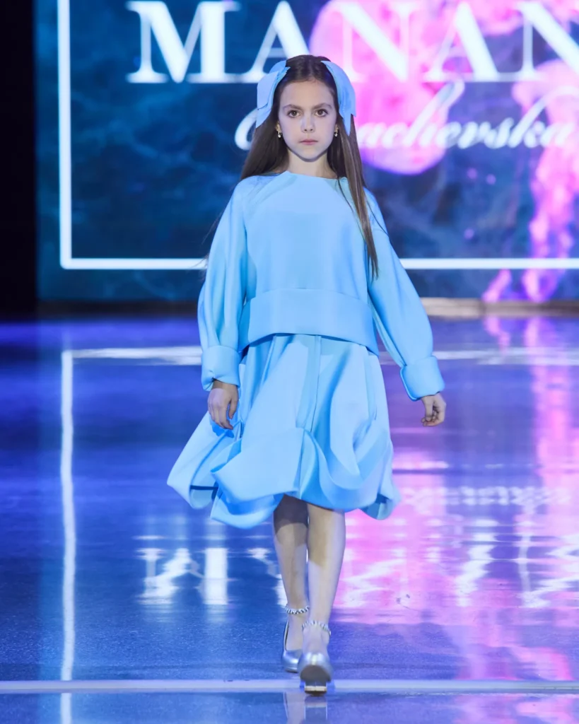 Plava dječja haljina s voluminoznom suknjom i širokim gornjim dijelom.