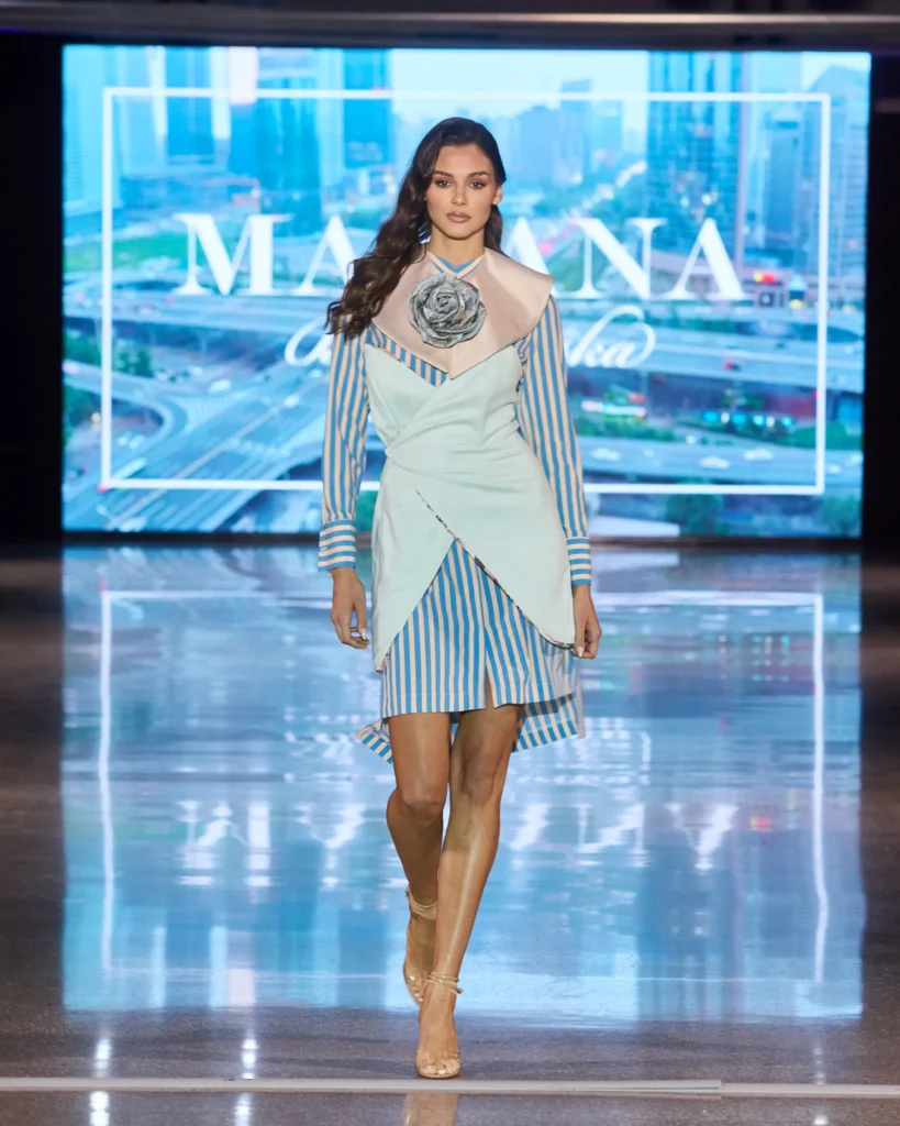 Prugasta košulja-haljina s asimetričnim slojevima i oversized cvjetnim ukrasom.