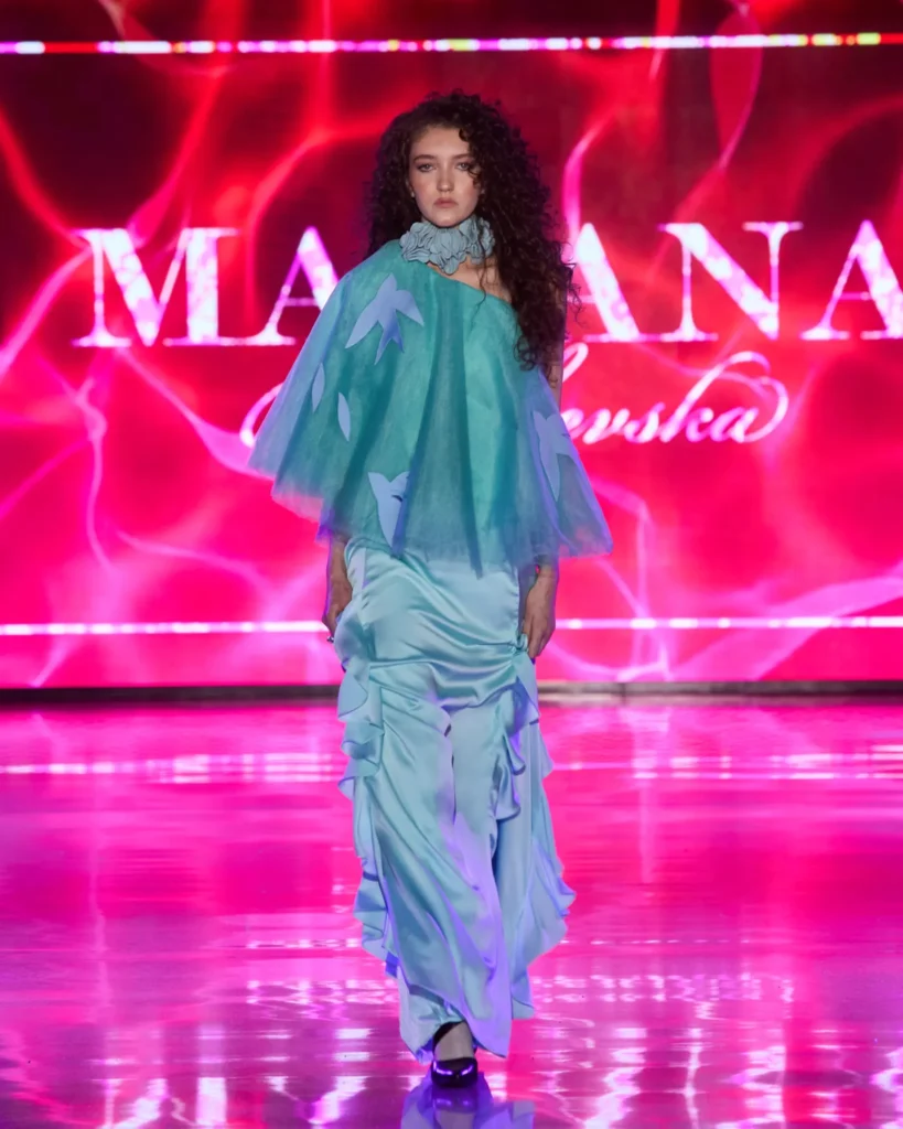 Tirkizna haljina s dramatičnim til kaputićem i asimetričnim siluetama.