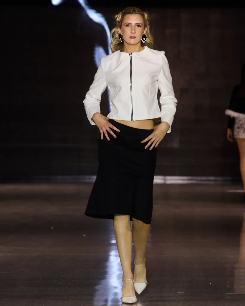 Kreacija MAZZA Atelier by Ajdin Hirkić: bijela minimalistička jakna s patentnim zatvaračem i crna midi suknja.