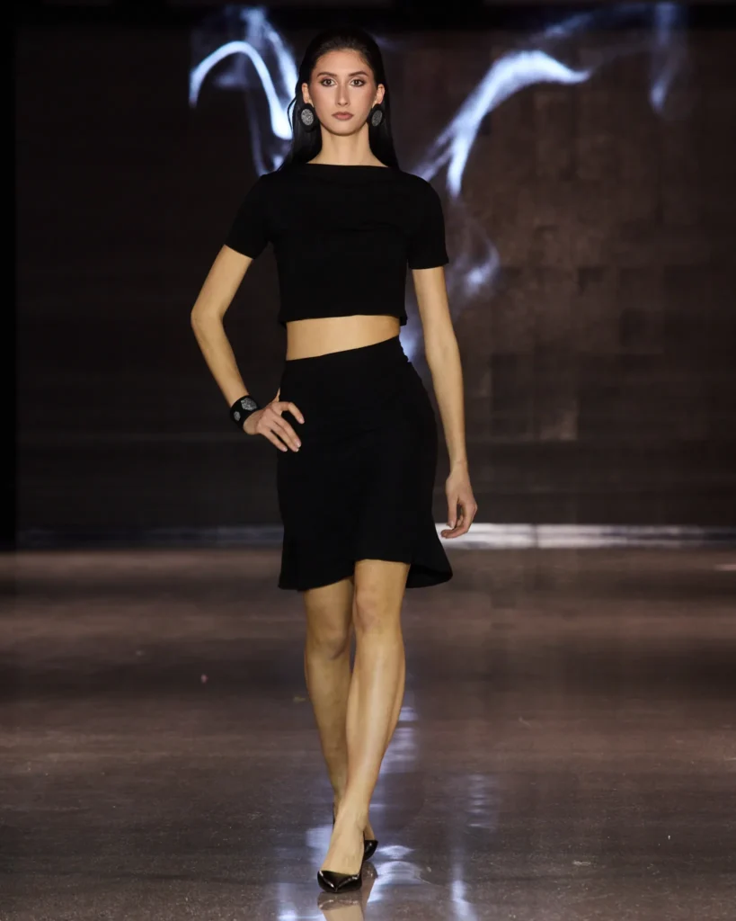 MAZZA Atelier by Ajdin Hirkić: crni crop top kratkih rukava uz crnu midi suknju asimetričnog kroja.