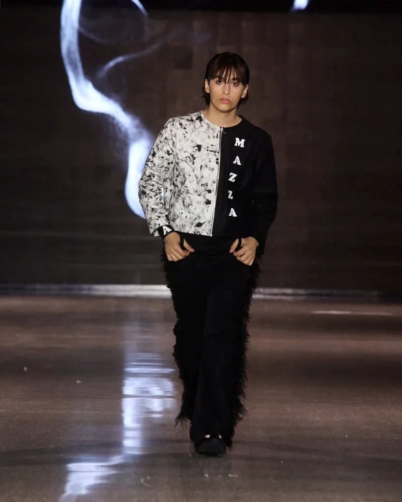 MAZZA Atelier by Ajdin Hirkić: crno-bijela jakna s podijeljenim printom i MAZZA natpisom uz crne hlače.
