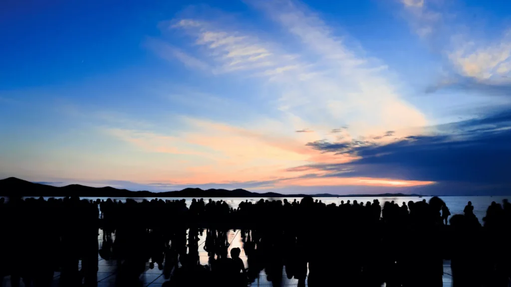 Sunset over Adriatic Sea from Greeting to the Sun Zadar installation with visitors gathered