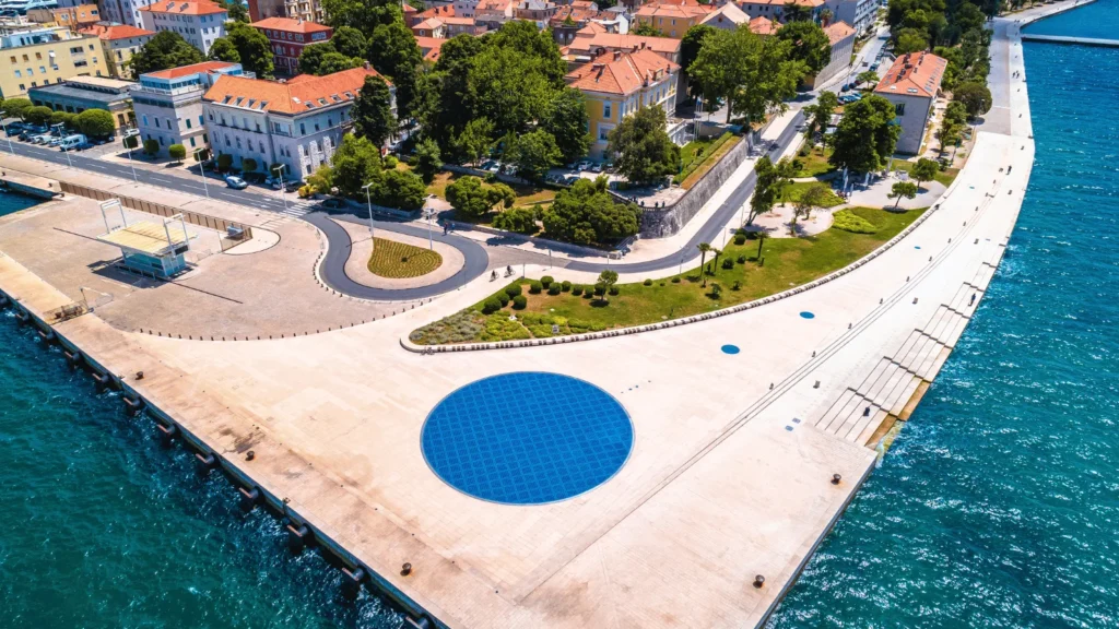 Zadar old town aerial Adriatic perspective revealing the compact city layout, stone rooftops and turquoise sea below.