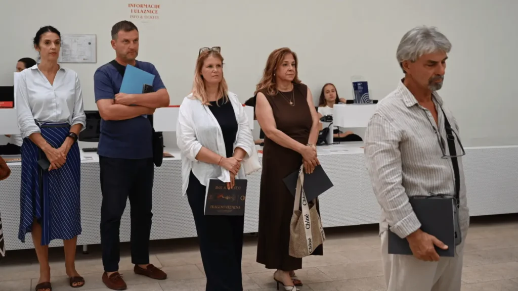 Ljudi stoje u redu u izložbenom prostoru