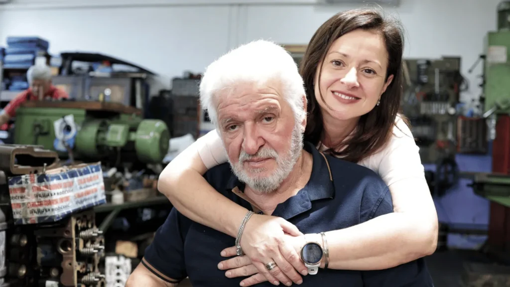 Žena grli starijeg muškarca u radionici