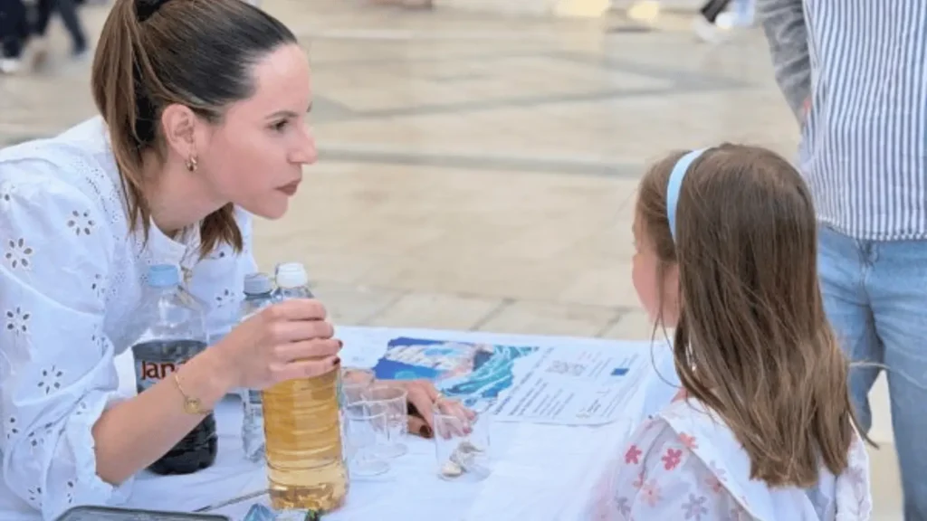 Žena objašnjava nešto djevojčici za stolom